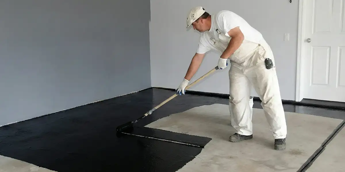 basement waterproofing professional applying waterproof coating to protect a basement floor in Charleston, SC
