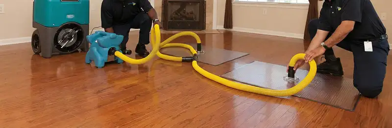 emergency water removal technicians extracting standing water from a home using professional equipment in Charleston, SC